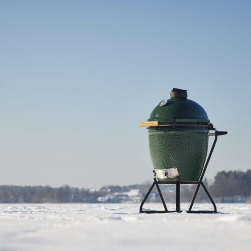 Big Green Egg Large im Winter auf einer Schneelandschaft mit klarem Himmel.